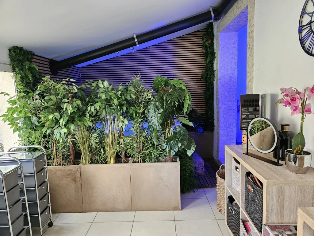 Coin confort avec de nombreuses plantes vertes, éclairage bleu et éléments de décoration intérieure.